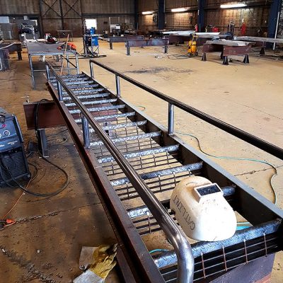 A bench in an industrial setting with many tables.